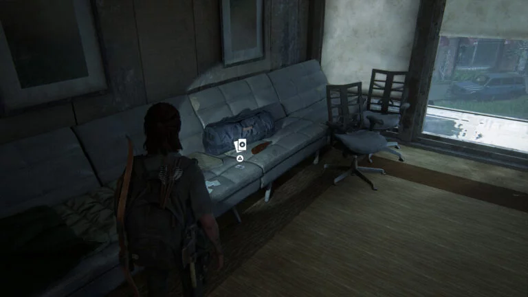 Die Sammelkarte Shift auf der Couch neben einer WLF-Tasche in The Last of Us 2