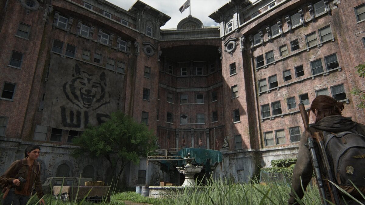 Ellie and Dina (with drawn gun) on the forecourt of the Serevena Hotel in The Last of Us 2.