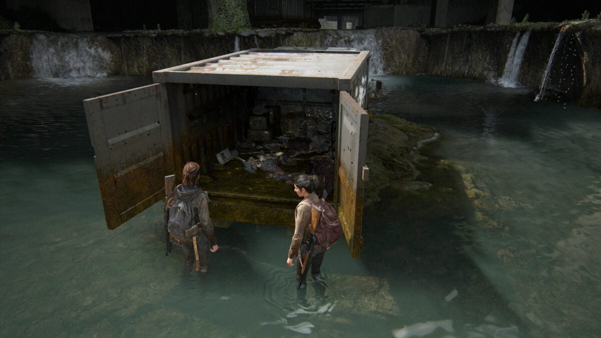 Ellie and Dina in front of the open cargo hold of a military transport in Downtown Seattle in The Last of Us 2.