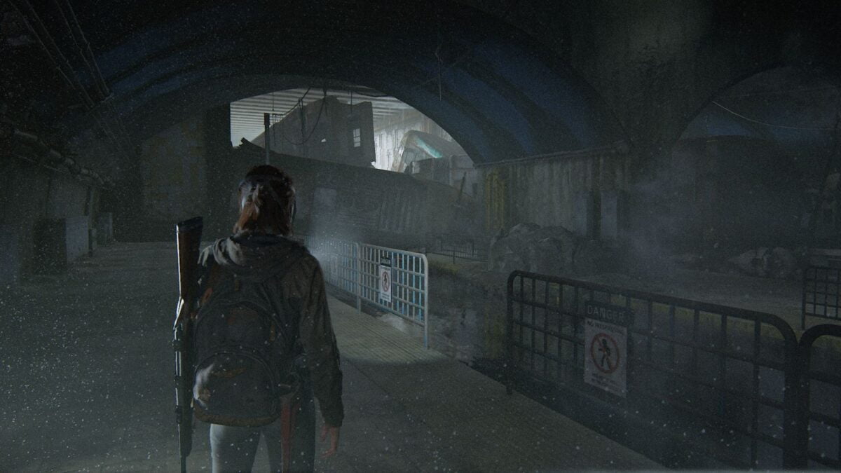 Ellie steht in den Tunneln von The Last of Us Part 2 vor U-Bahn-Wracks.