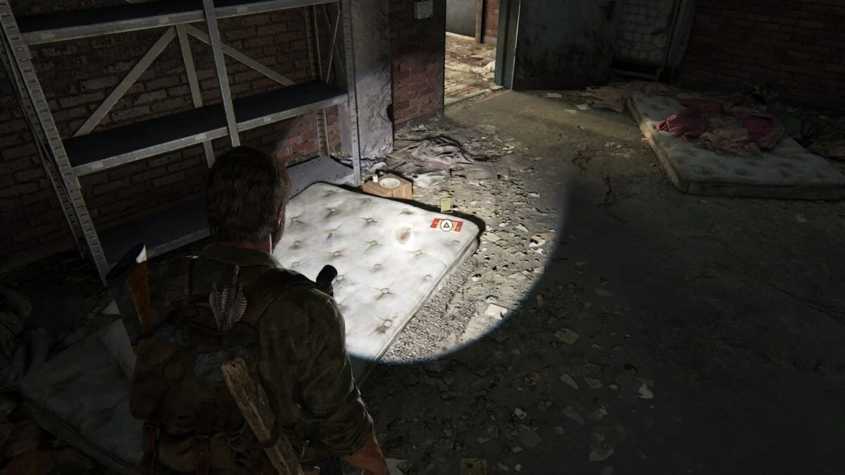 Das zweite Trainingsbuch in The Last of Us Part 1 findet ihr auf dieser Matratze im Hunter-Lager.