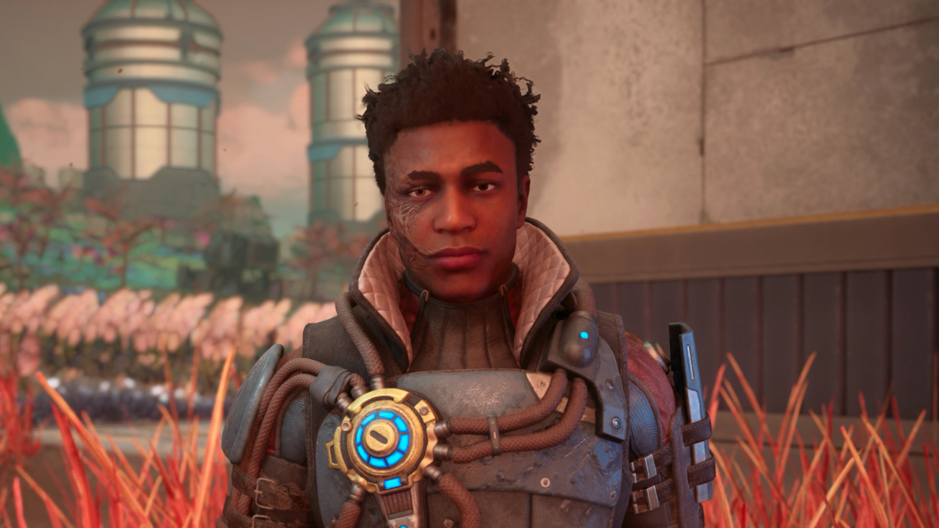 Ein junger Mann mit Narben im Gesicht und futuristischer Ausrüstung steht vor einer Forschungsanlage – Spielszene aus The Outer Worlds 2.