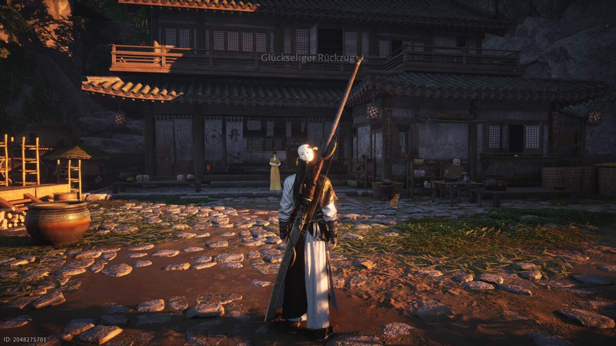 Maskierter Charakter in langer Robe steht im warmen Abendlicht auf einem gepflasterten Hof vor einem traditionellen asiatischen Holzhaus; im Hintergrund eine Frau in gelbem Gewand und eine Katze am Rand.