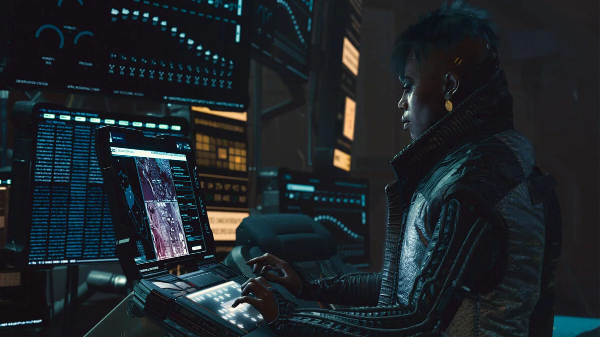 Cyberpunk 2077 Netrunner der Vodoo Boys steht vor mehreren Bildschirmen und hackt sich in ein System