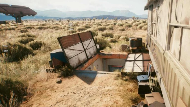Cyberpunk 2077 Kleidung-Guide offener Bunker mit Treppe abwärts hinter Trailer in der Wüste