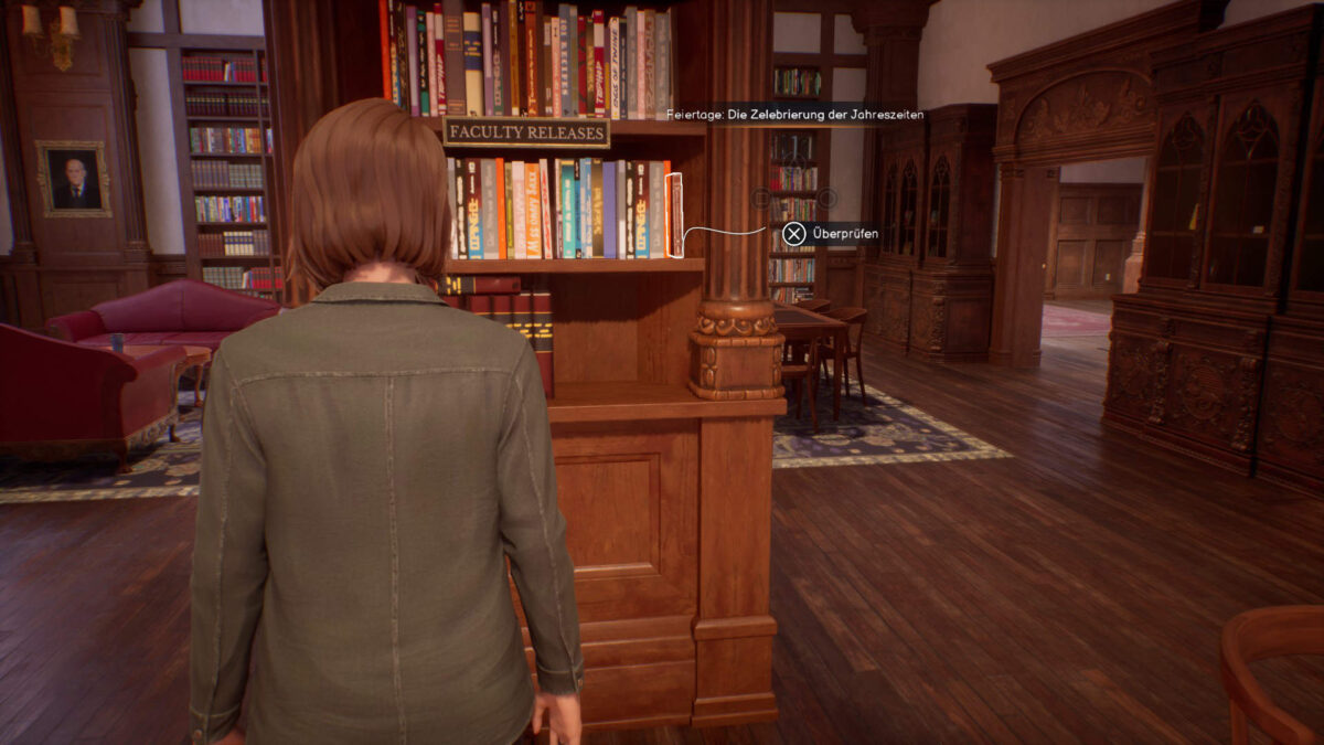 Max steht vor einem Holzregal mit unzähligen Büchern drin.