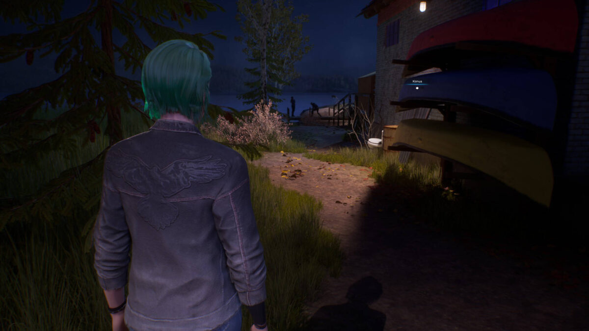 Chloe steht neben einigen Kanus an der Wand.