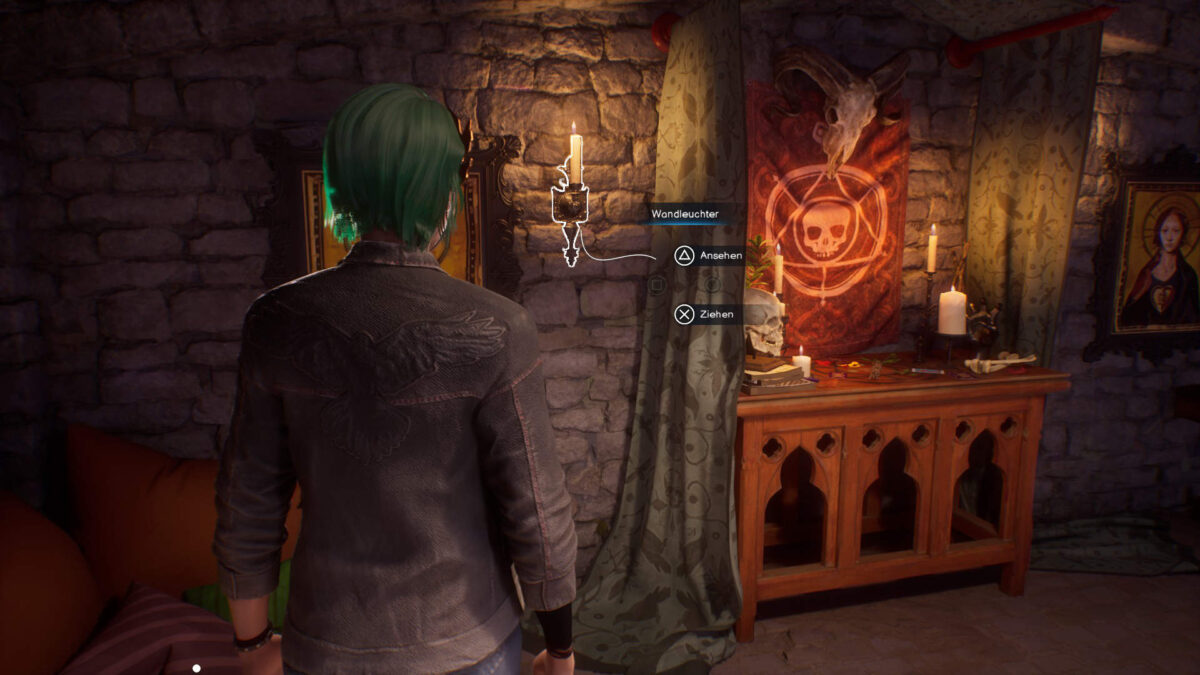 Chloe steht vor einer Wand mit einem Kerzenständer dran.