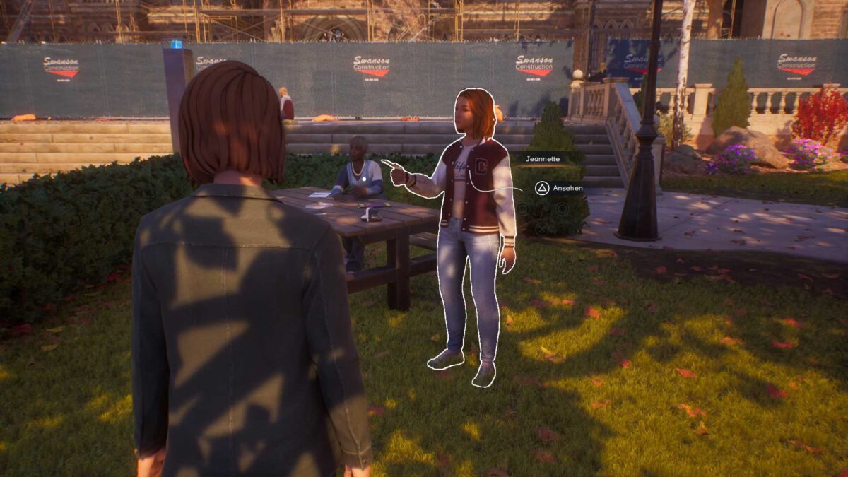 Jeanette mit einem Foto, steht neben einer älteren Frau an einem Tisch.