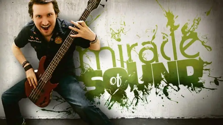 Gavin Dunne posiert mit seiner E-Gitarre vor dem Schriftzug "Miracle of Sound"